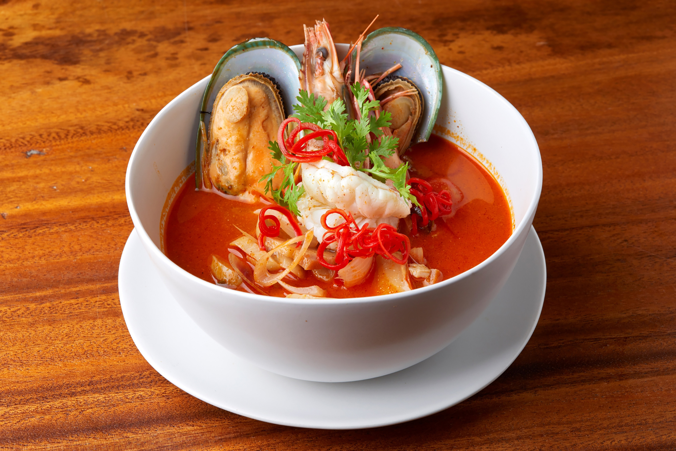 Spicy Tom Yum seafood soup with prawns, mussels, and chili.