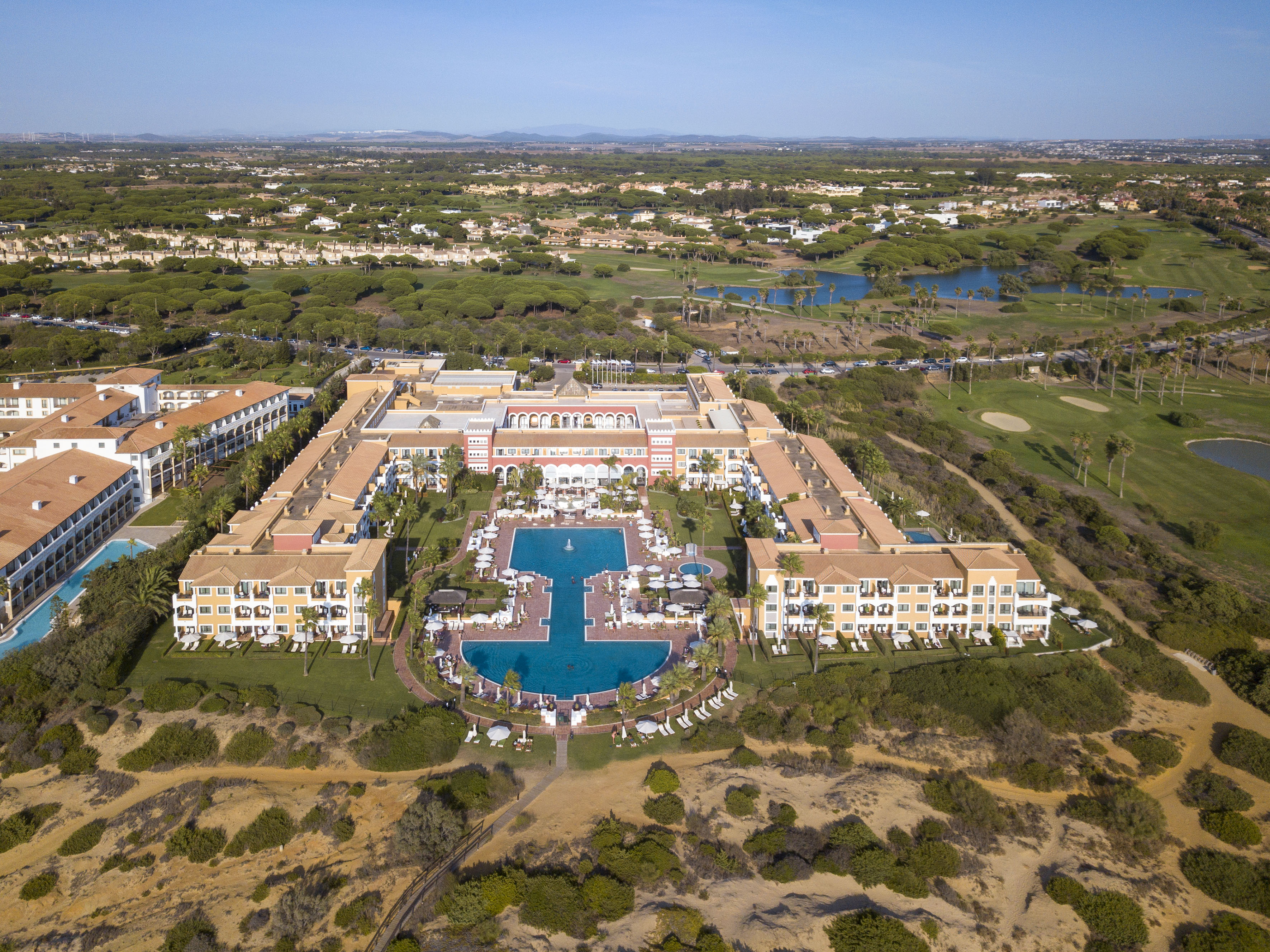 a large building with a pool and grass