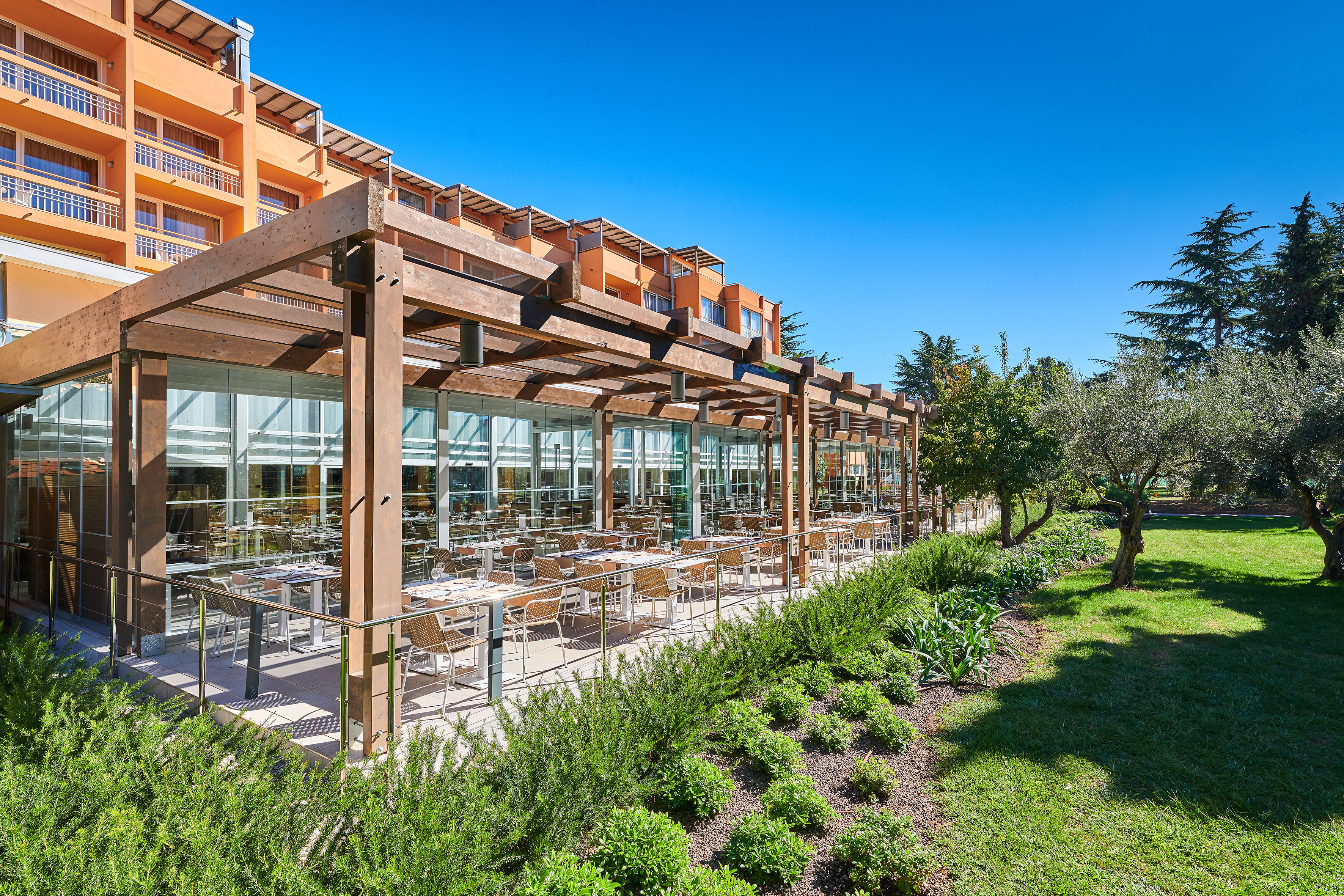 a building with a glass roof and tables outside