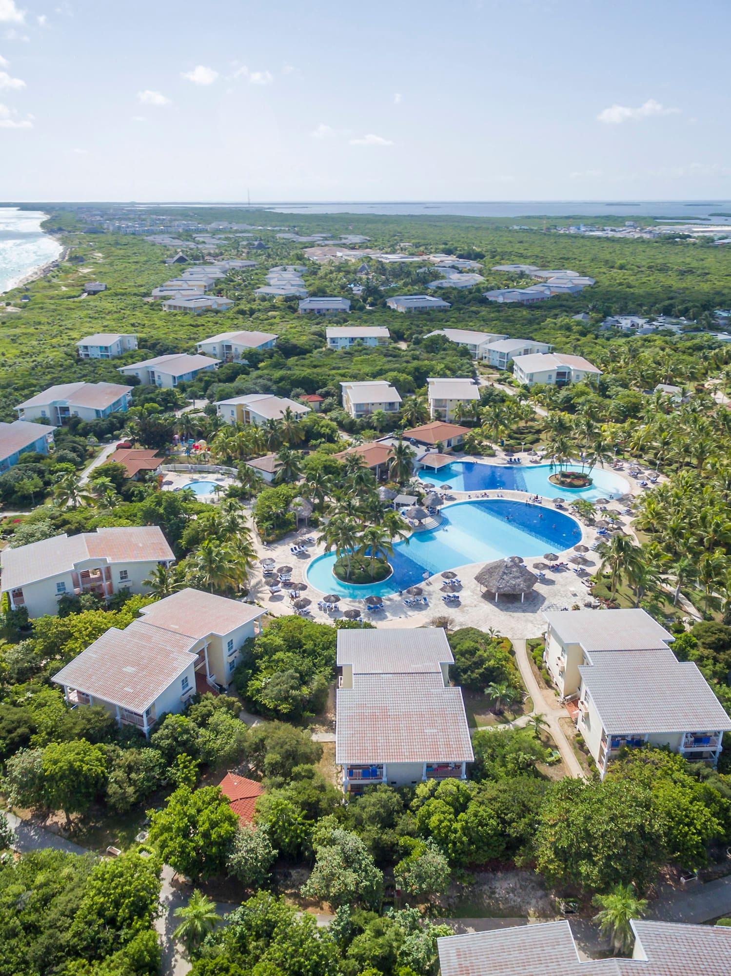 a group of houses with a pool in the middle of a body of water