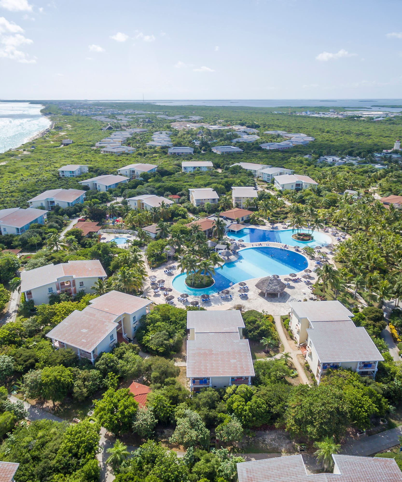 a group of houses with a pool in the middle of a body of water