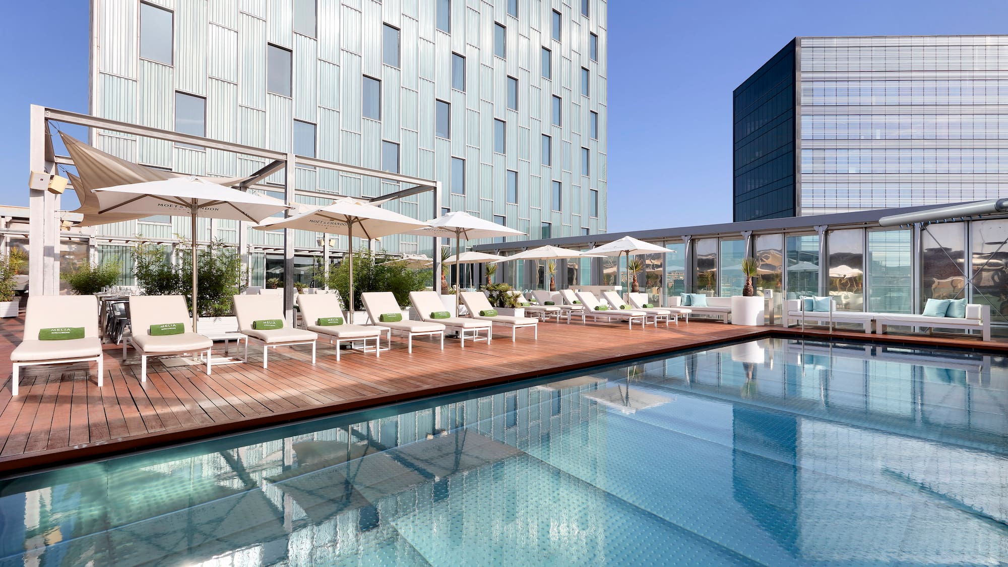 a pool with chairs and umbrellas in front of a building