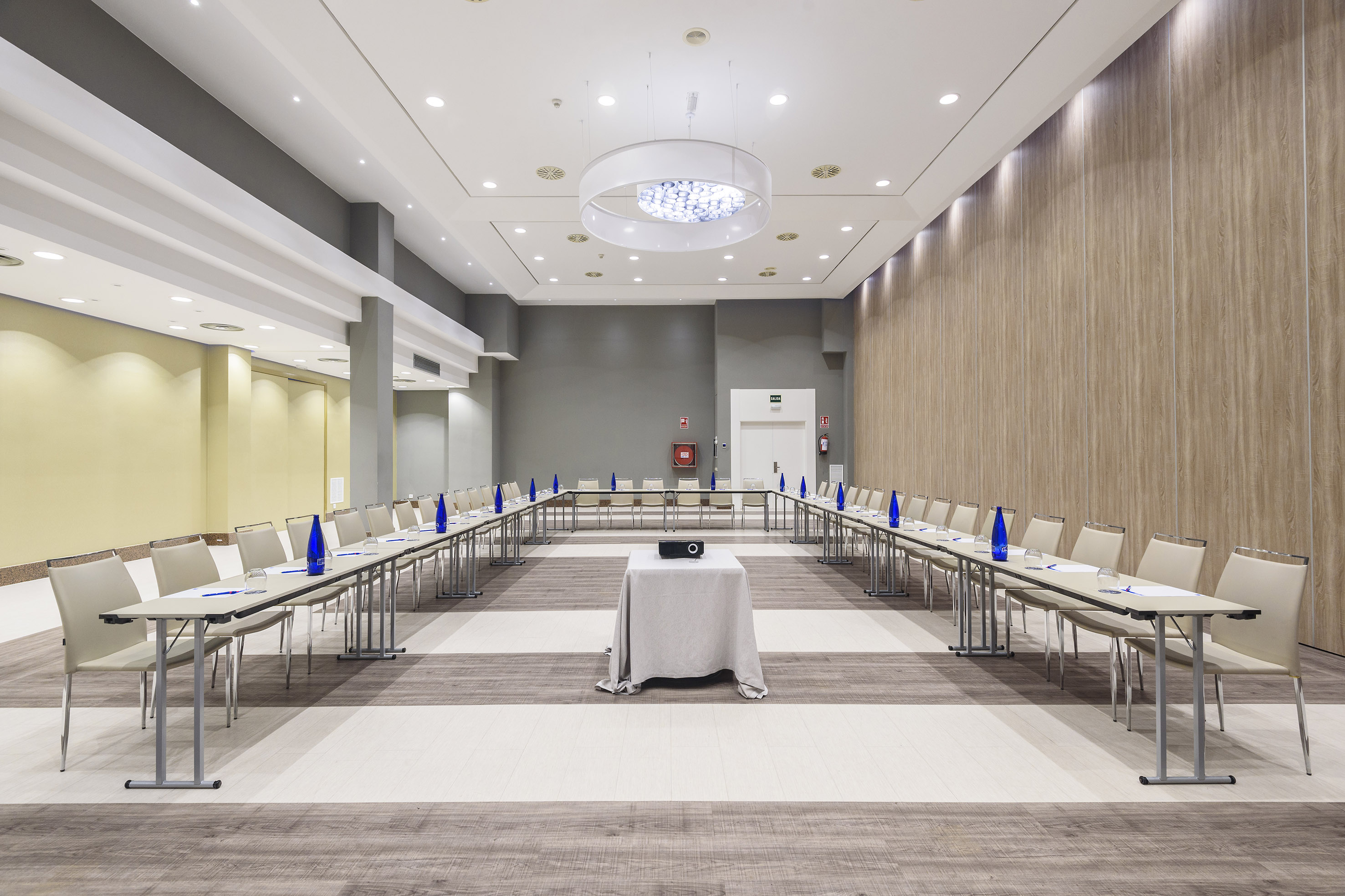 Spacious, modern conference room with U-shaped table setup and projector.
