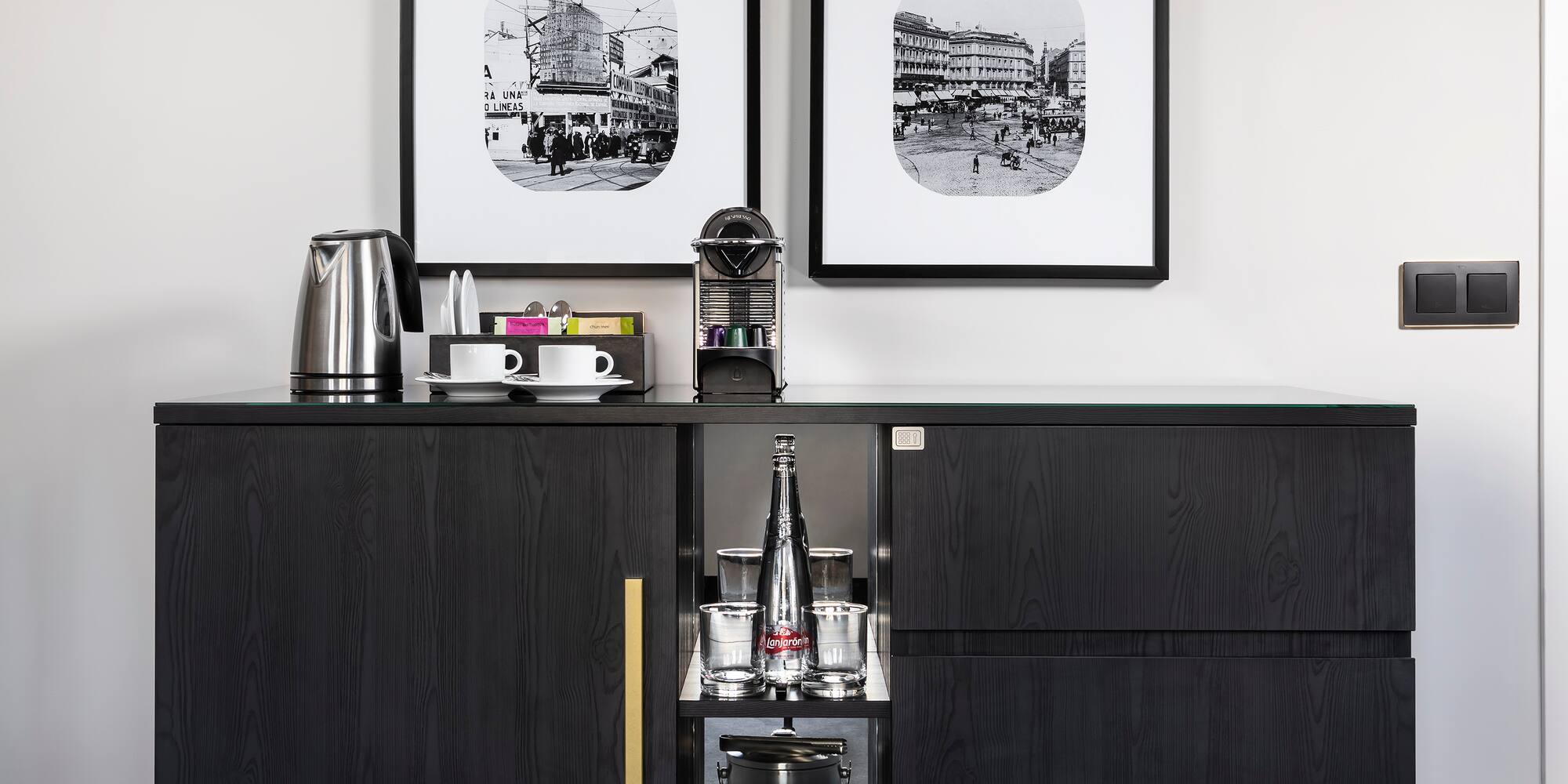 a black cabinet with a couple framed pictures on it