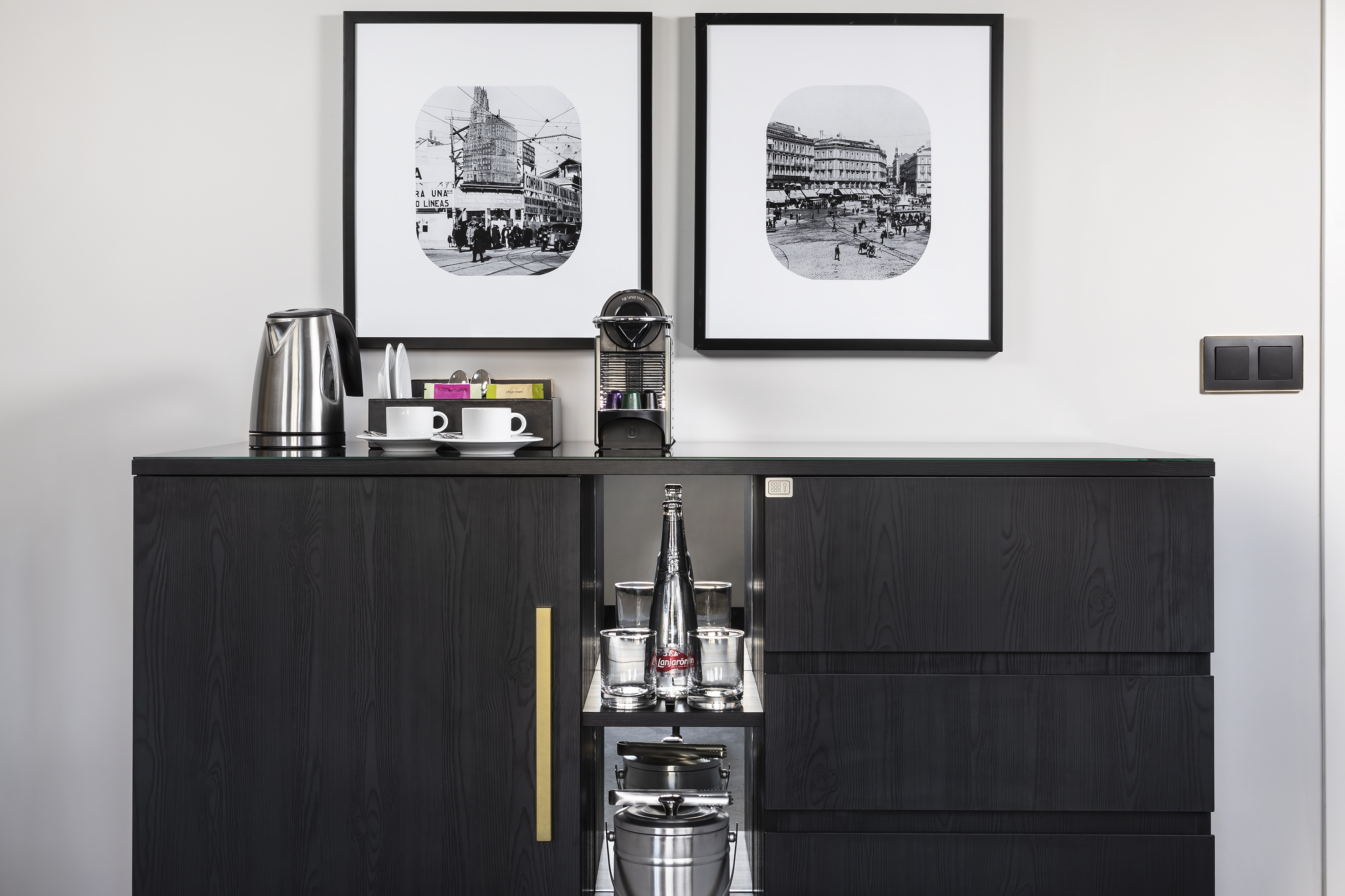 a black cabinet with a couple framed pictures on it