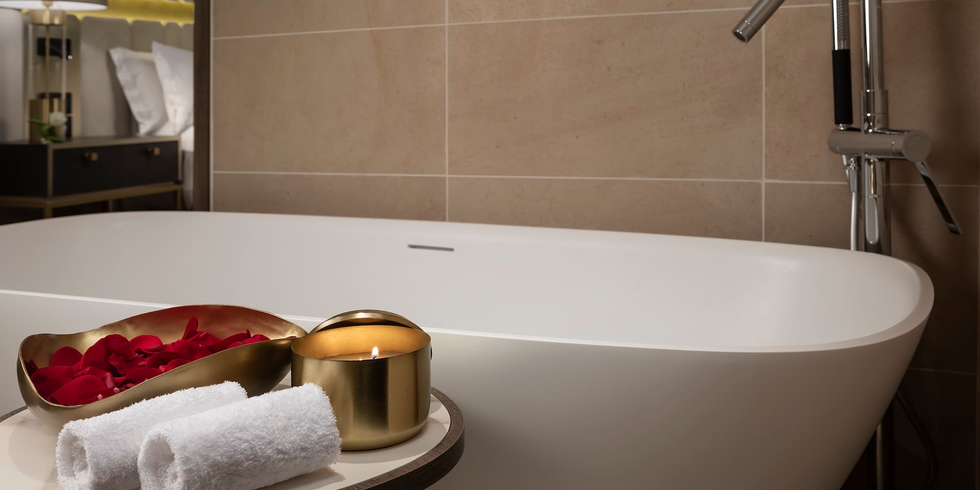 a bathtub with a candle and towels