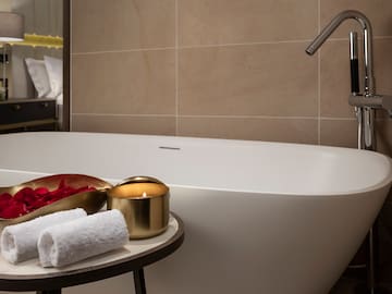 a bathtub with a candle and towels