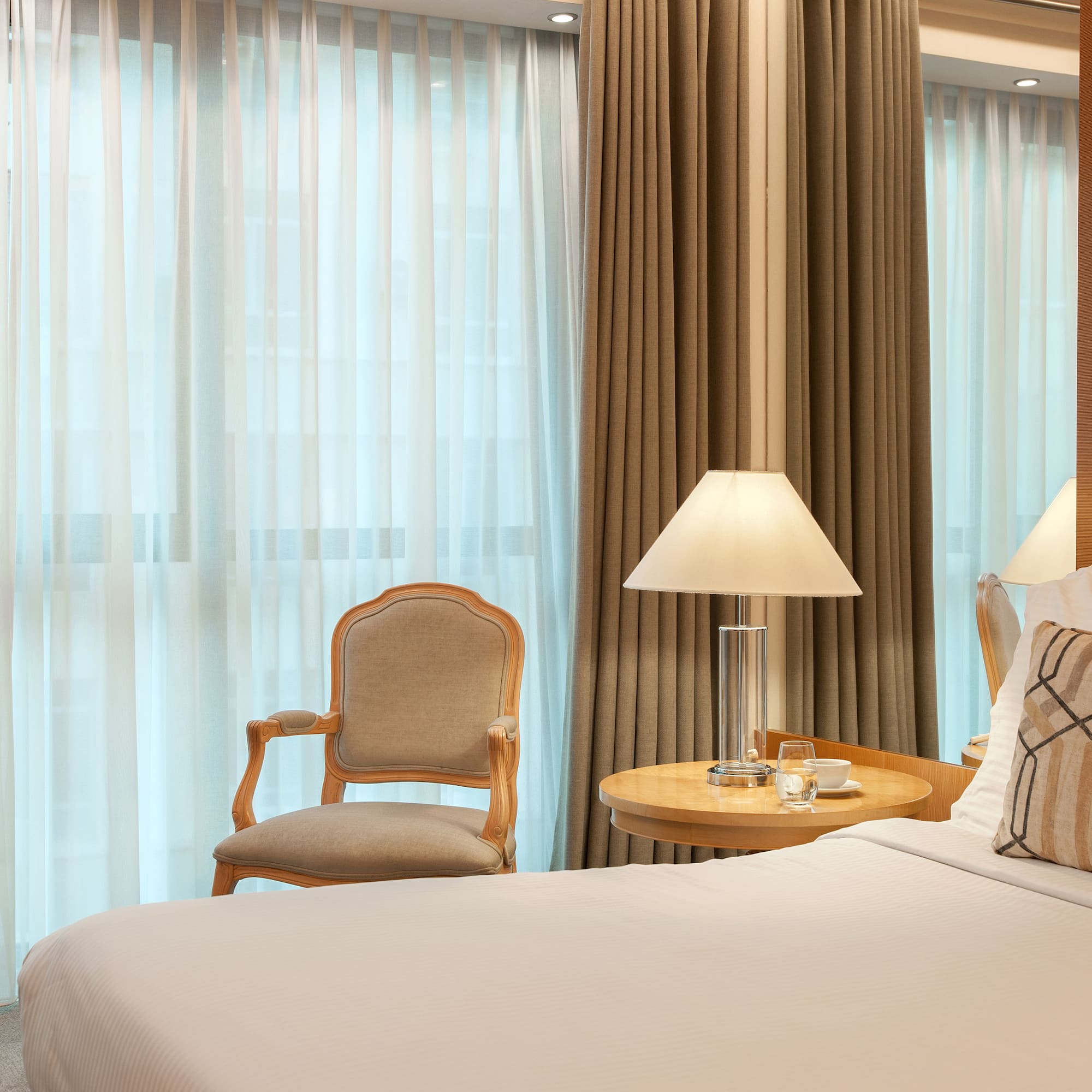 a bed with a lamp and a chair in a room