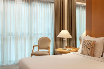 a bed with a lamp and a chair in a room