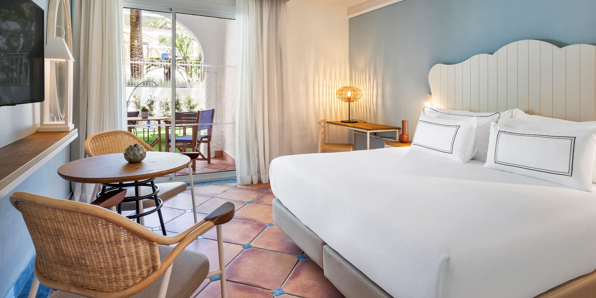 a room with a bed and chairs