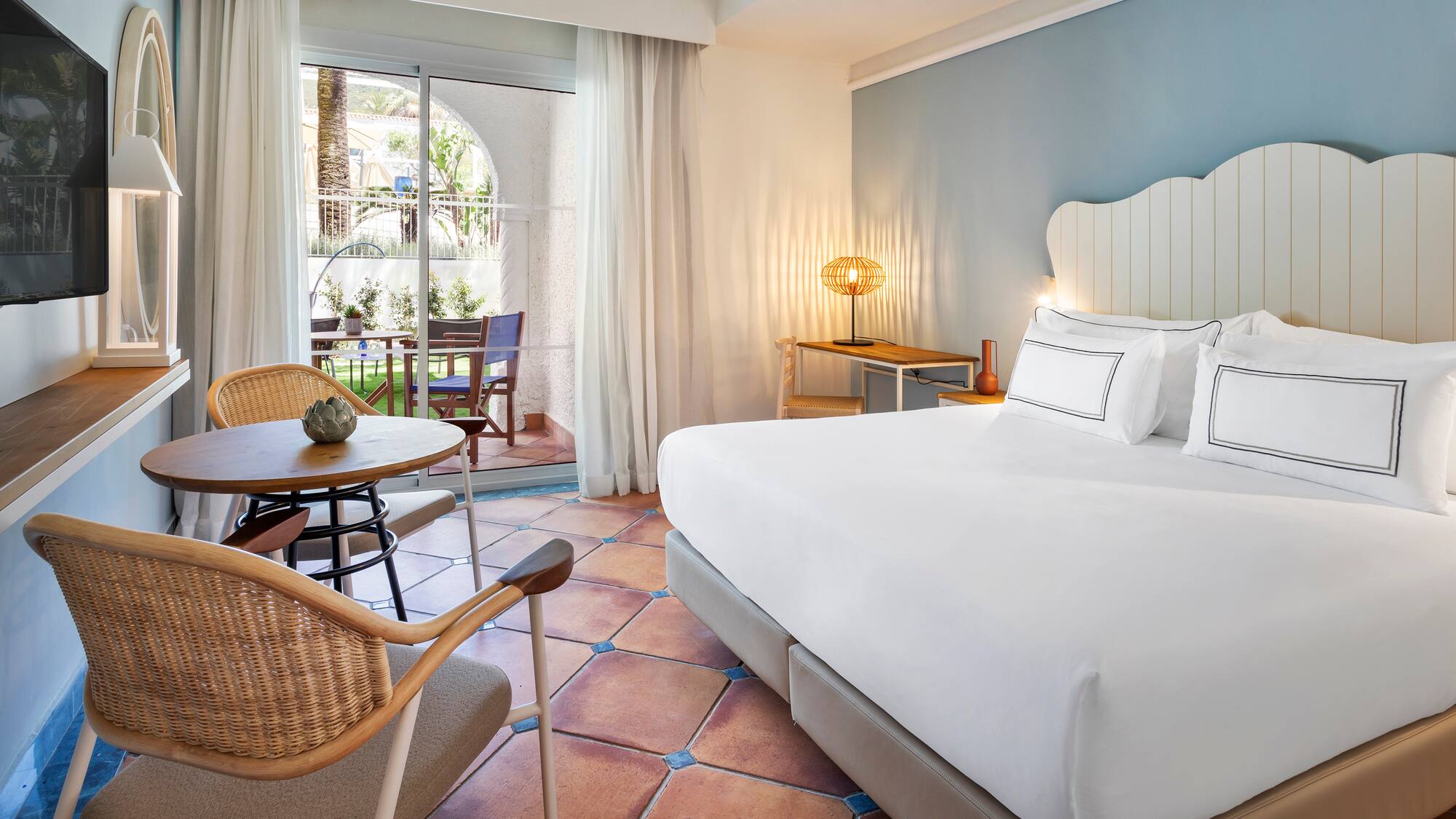 a room with a bed and chairs