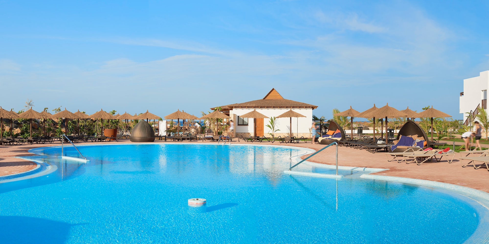 a pool with umbrellas and chairs