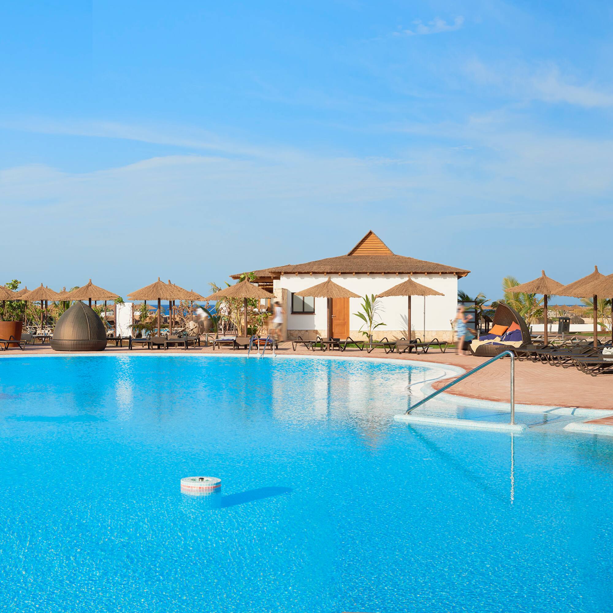 a pool with umbrellas and chairs