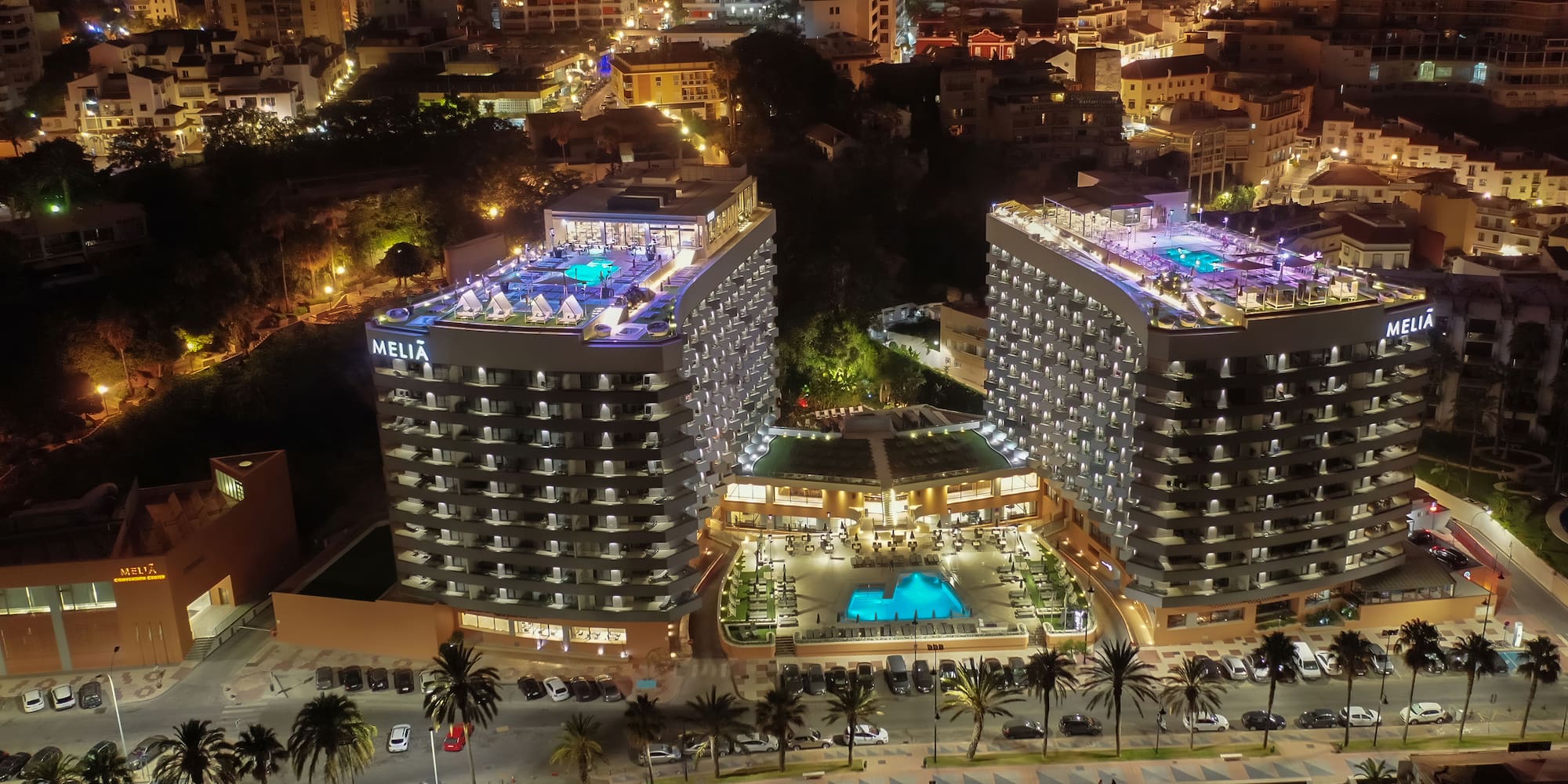 a large building with a pool and parking lot