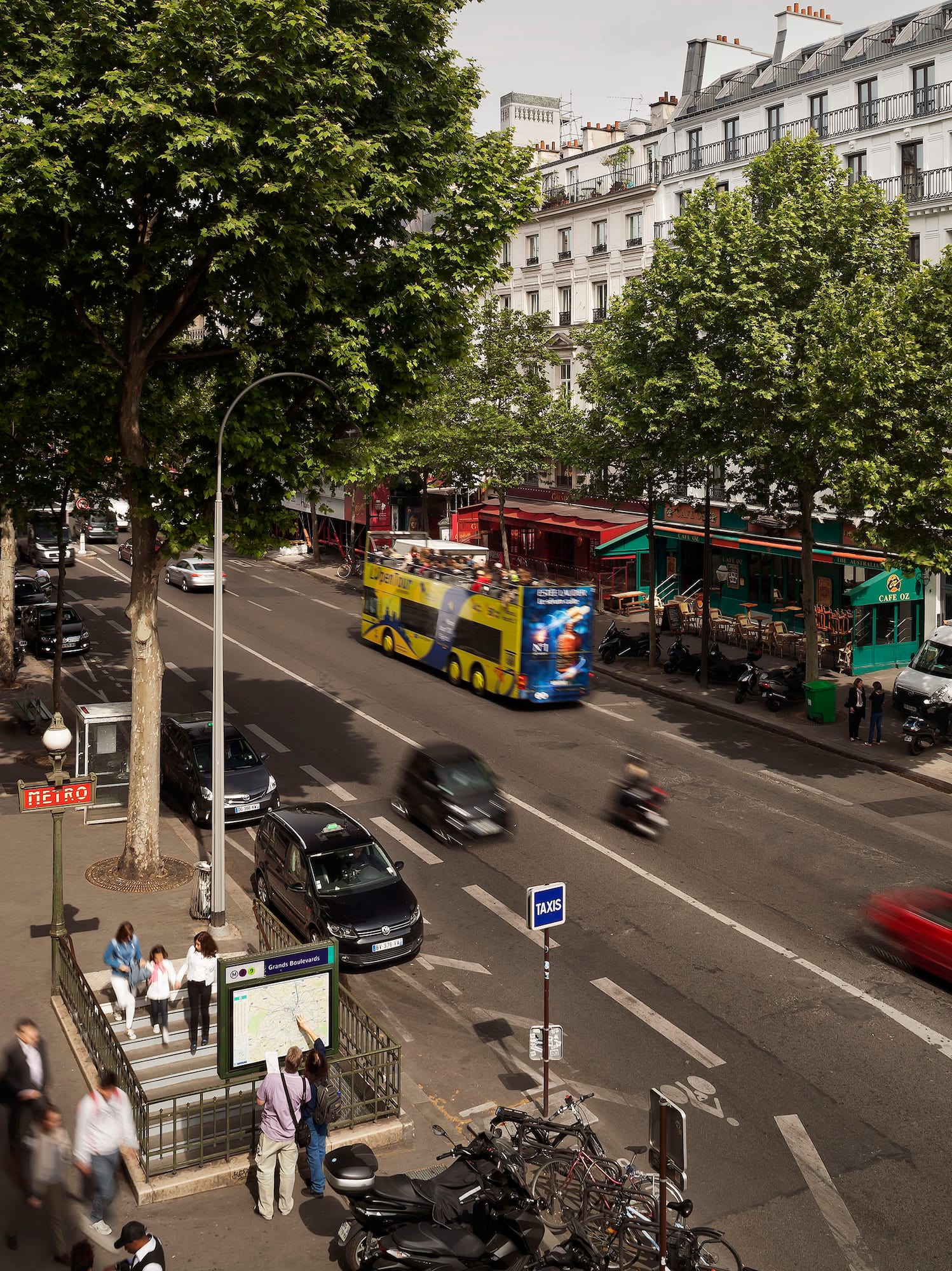 a city street with cars and people walking on the sidewalk