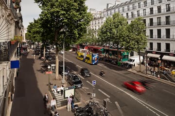 a city street with cars and people walking on the sidewalk