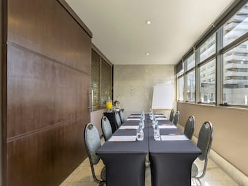 a long table with chairs and a white board in front of it