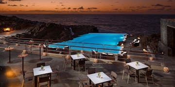 a pool with tables and chairs on a patio
