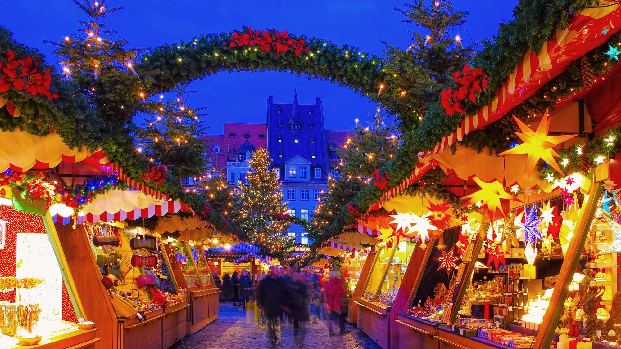 a group of people walking in a street with christmas decorations