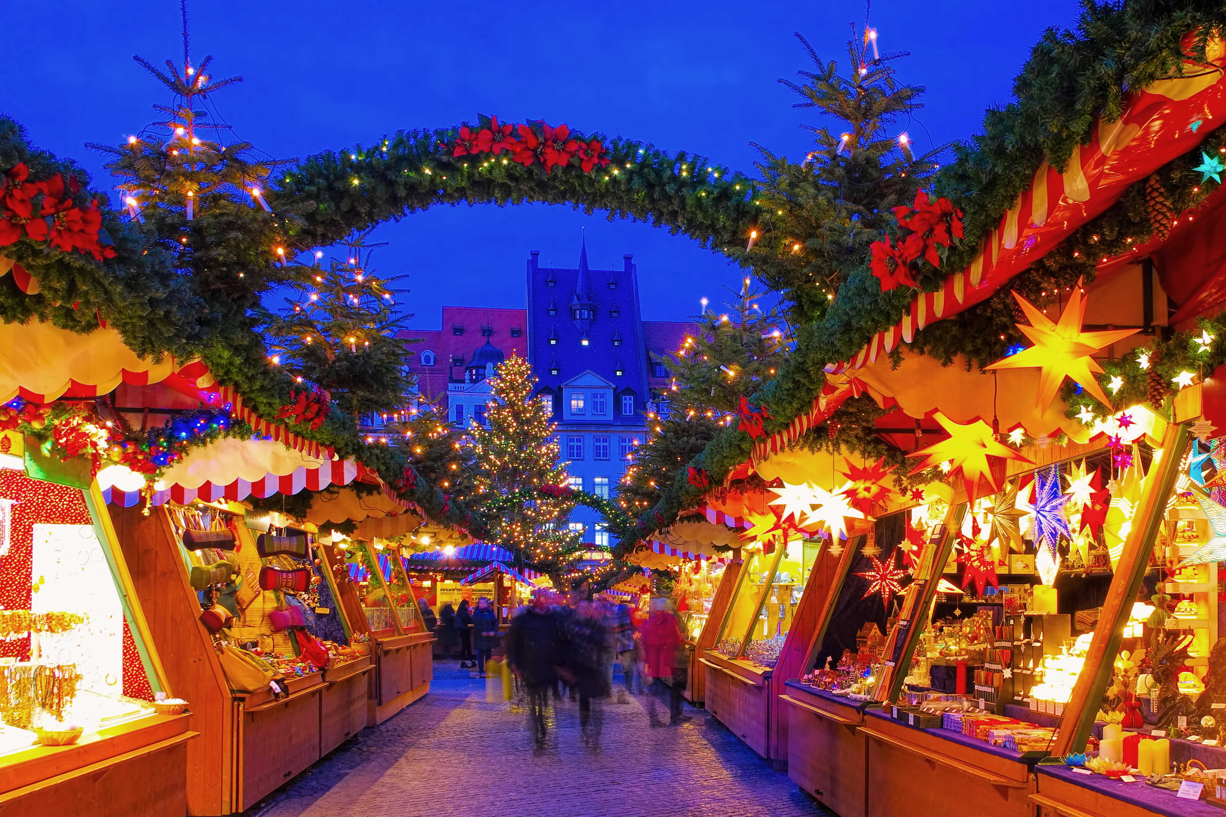 a group of people walking in a street with christmas decorations