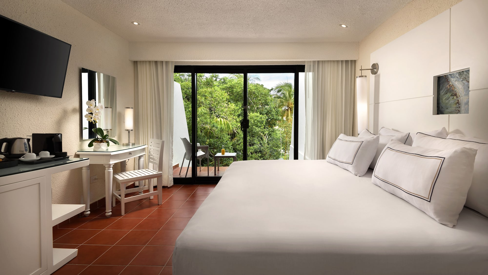 a bedroom with a large bed and a table and chairs