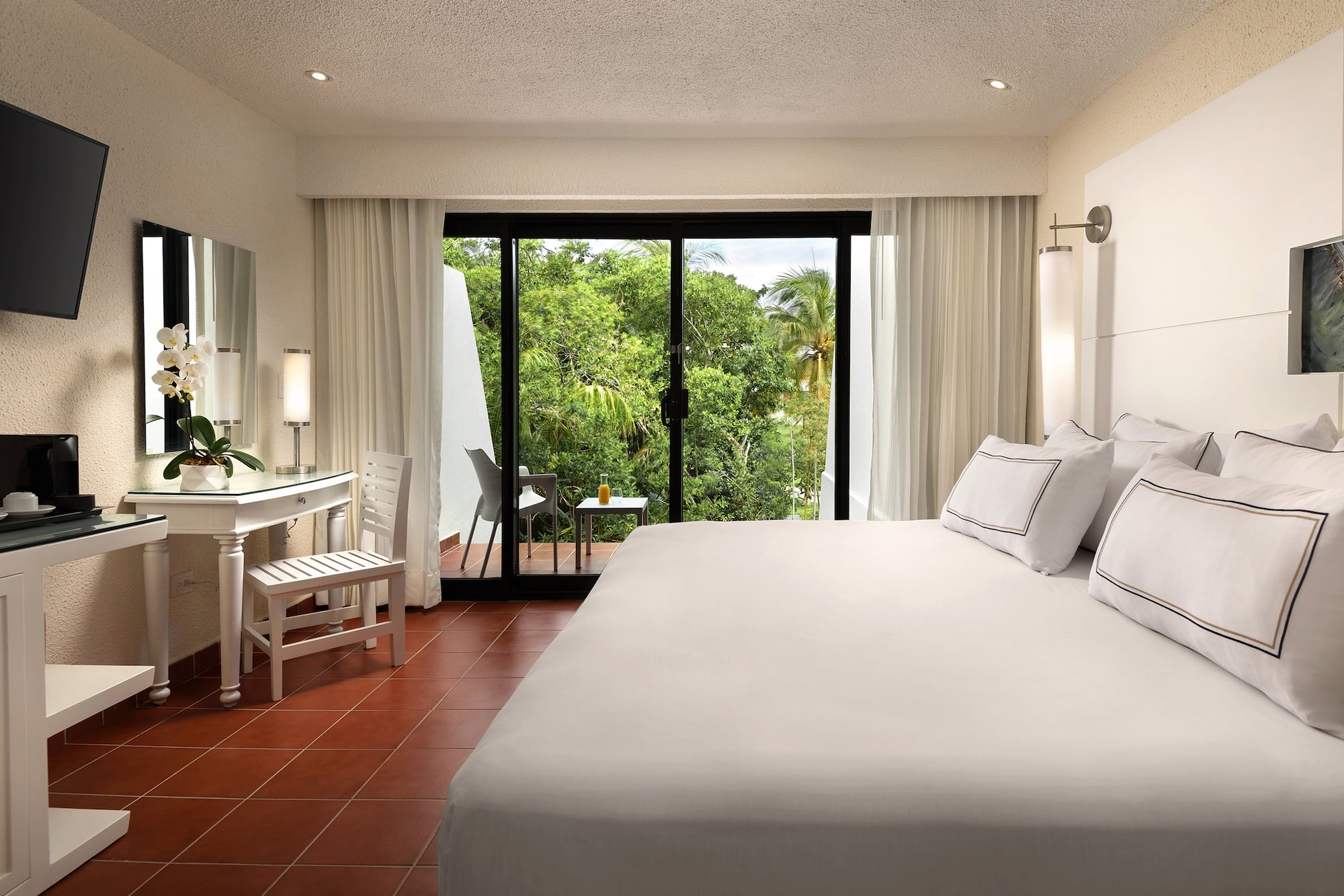 a bedroom with a large bed and a table and chairs