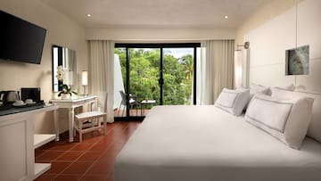 a bedroom with a large bed and a table and chairs