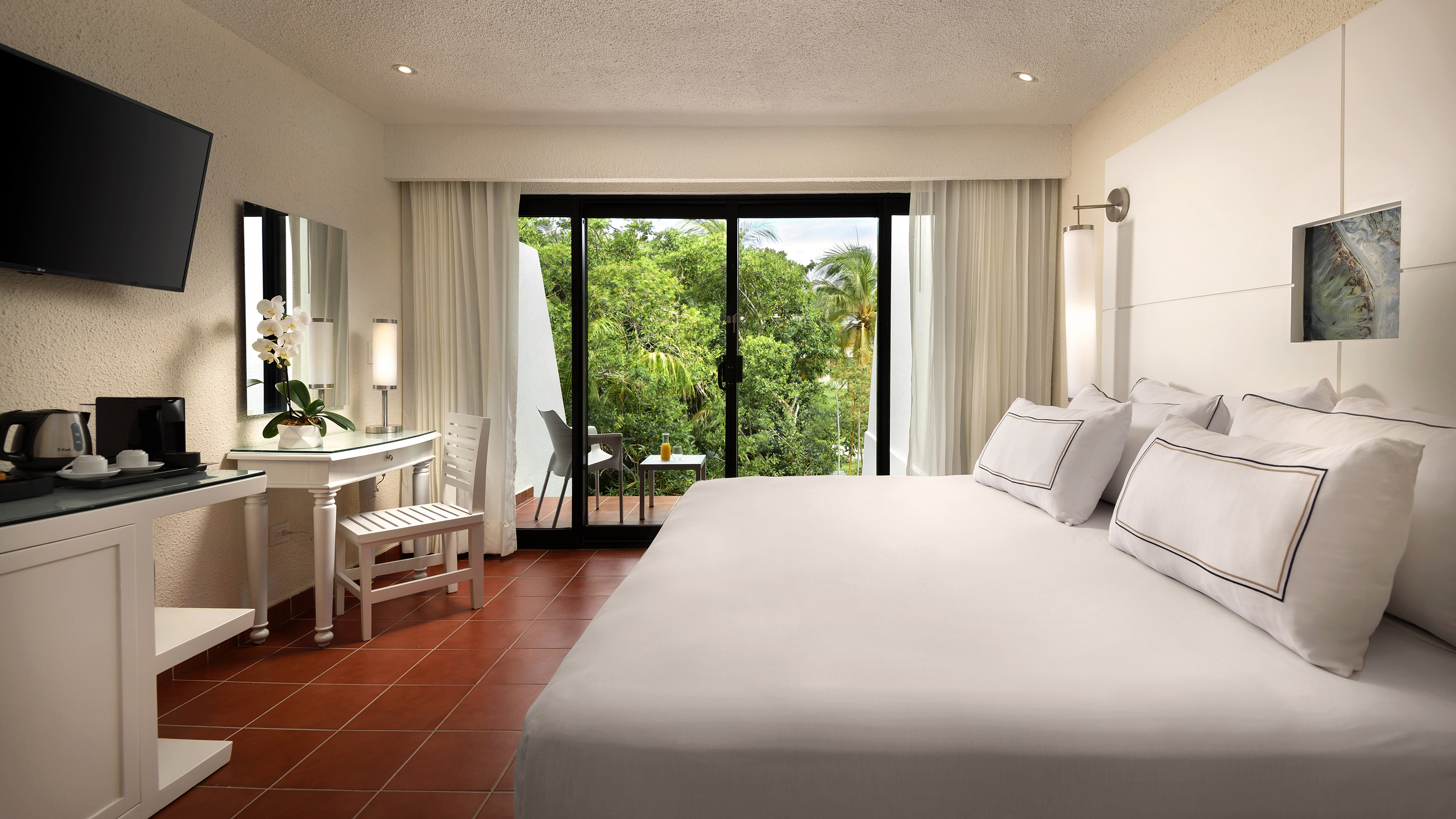 a bedroom with a large bed and a table and chairs