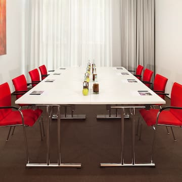 a table with red chairs and bottles of liquid on it
