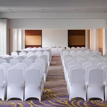a room with rows of white chairs