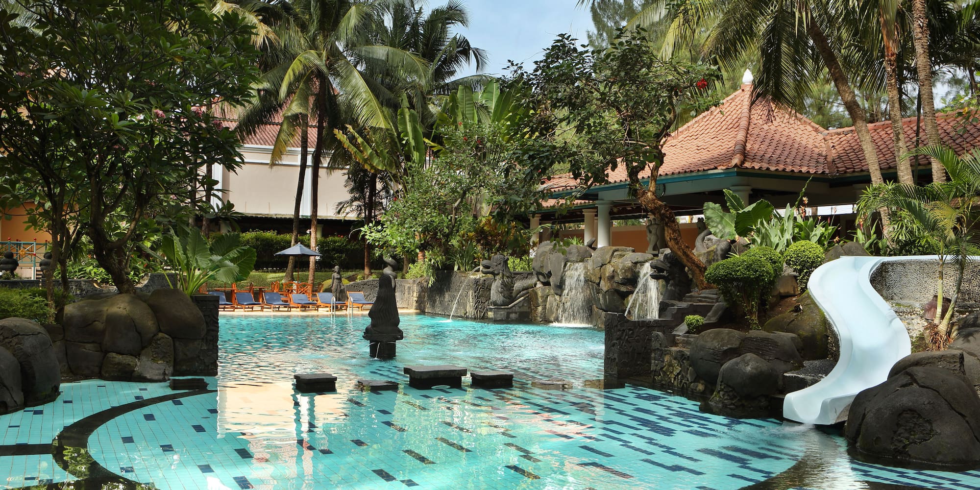 a pool with a waterfall and trees