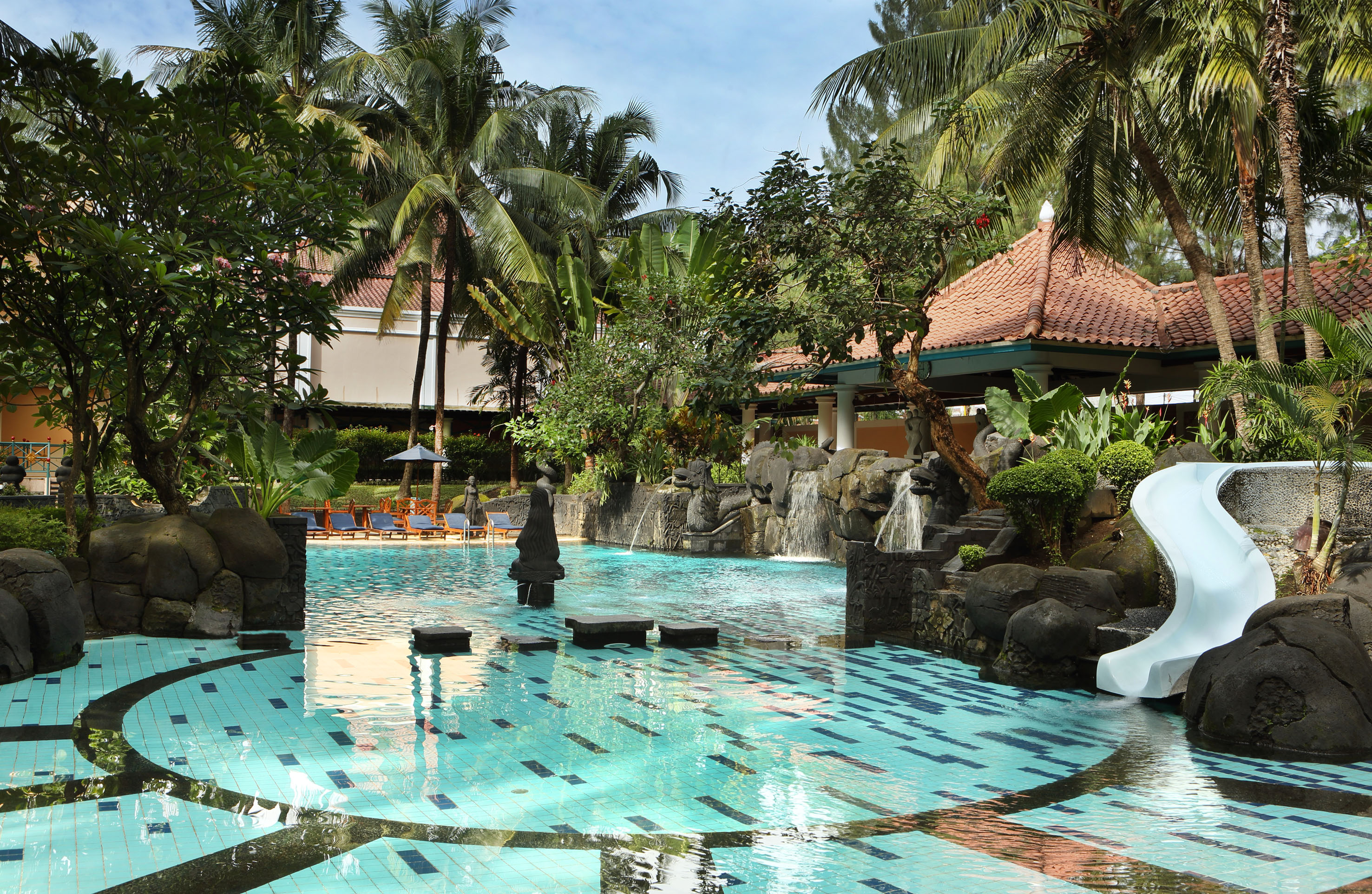 a pool with a waterfall and trees