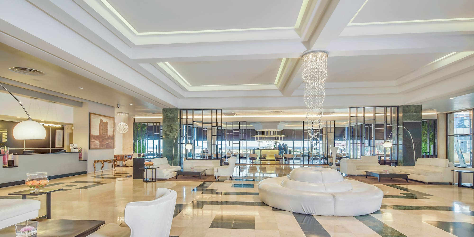 a large lobby with white furniture and a chandelier