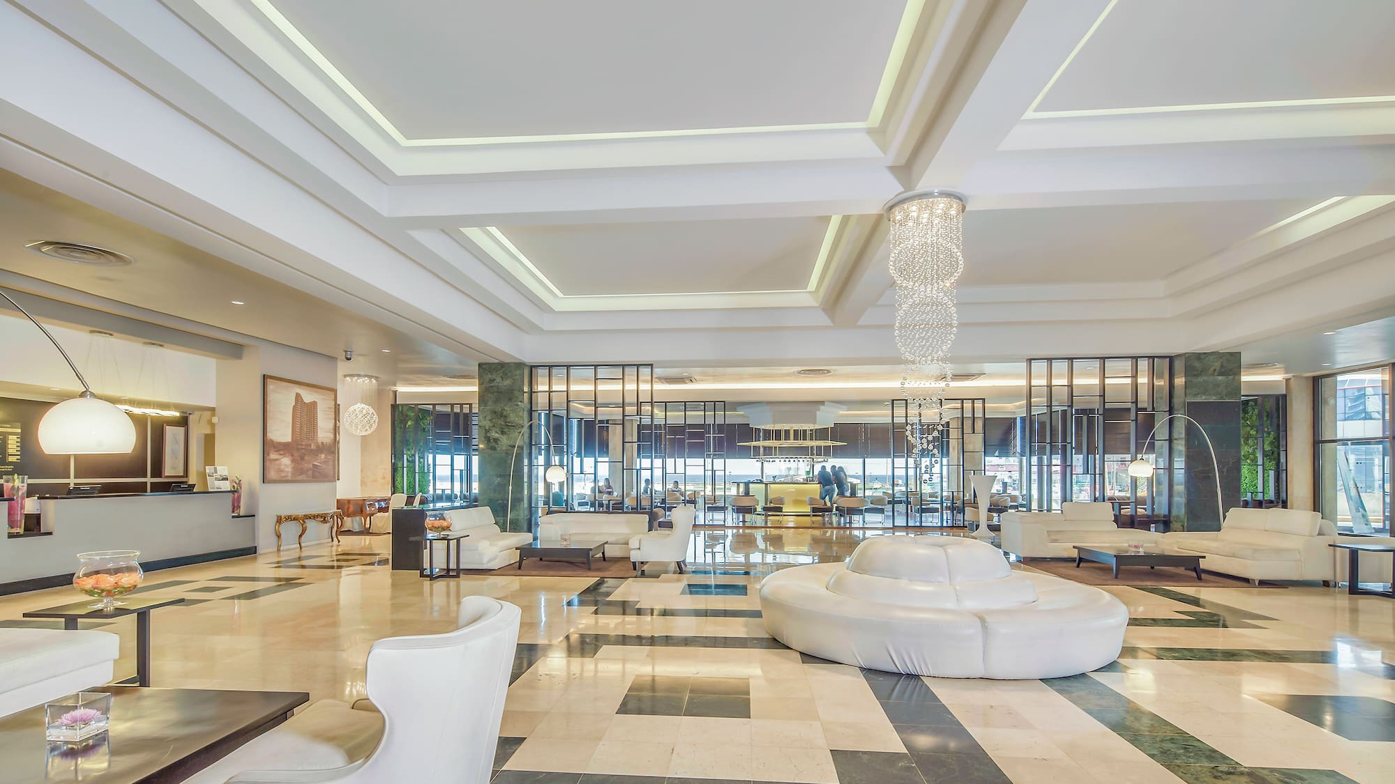 a large lobby with white furniture and a chandelier