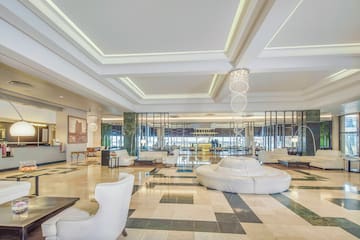 a large lobby with white furniture and a chandelier