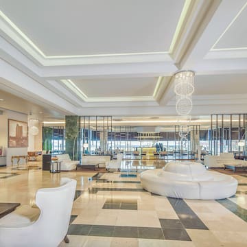 a large lobby with white furniture and a chandelier