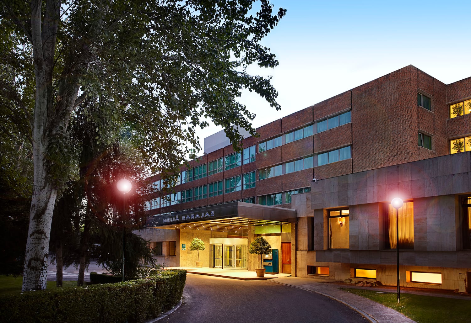 a building with a driveway and trees