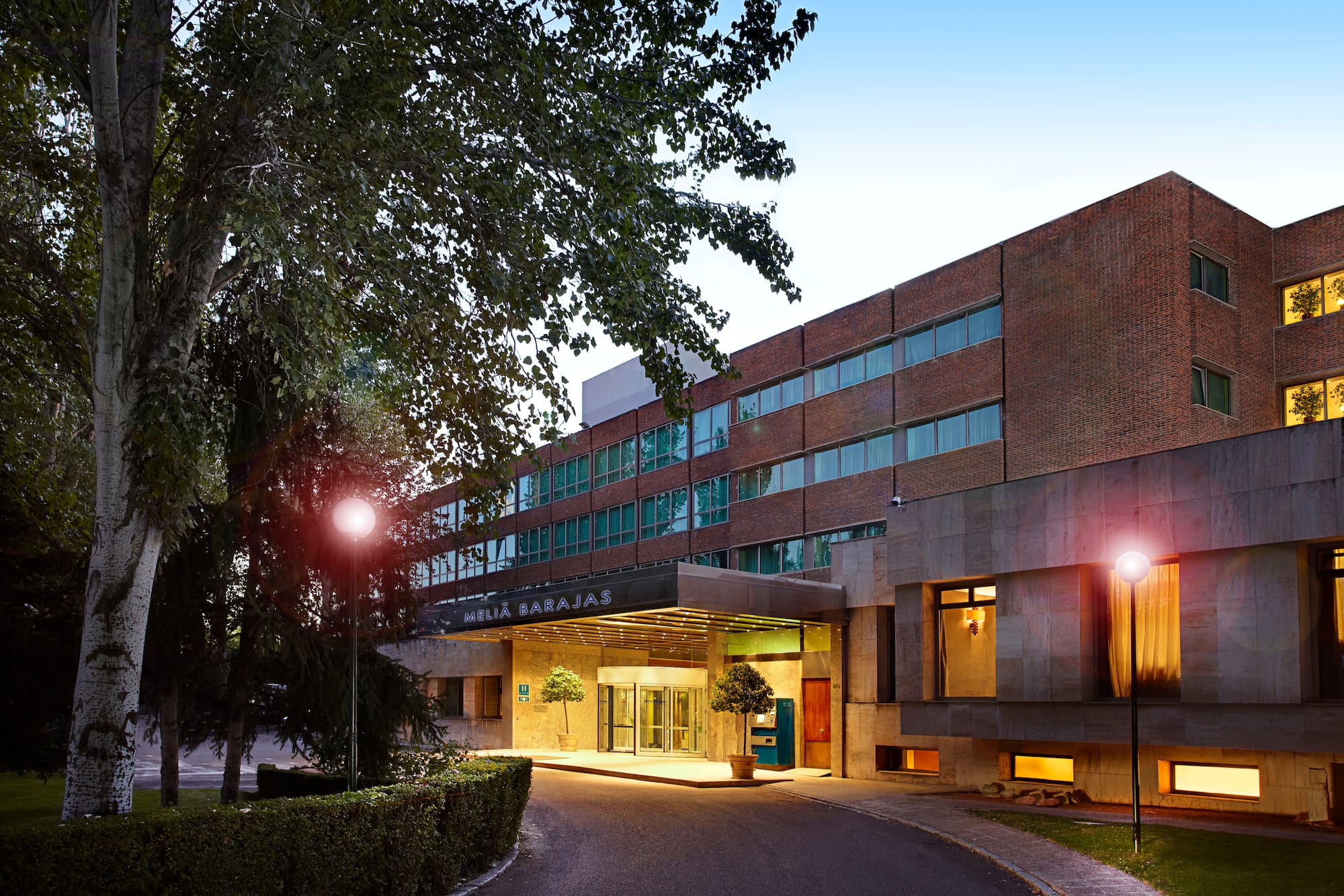 a building with a driveway and trees