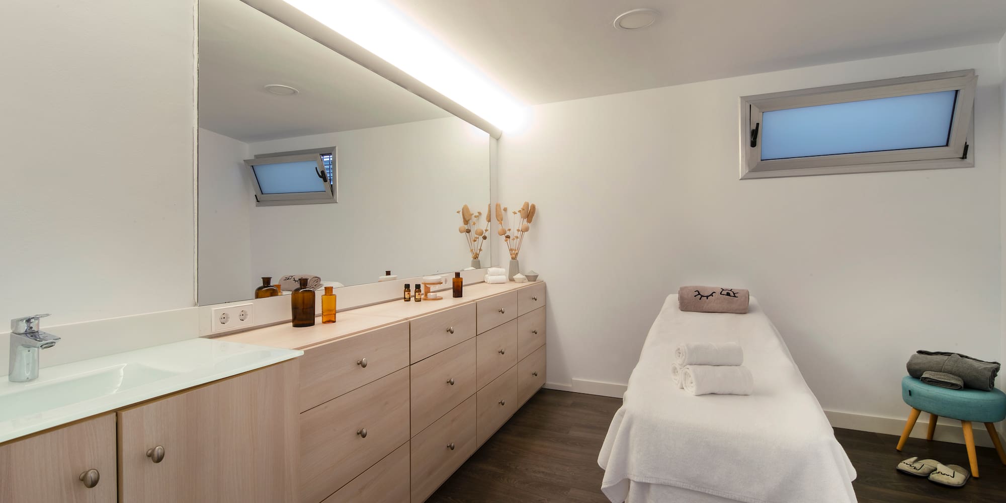 a room with a massage table and a mirror