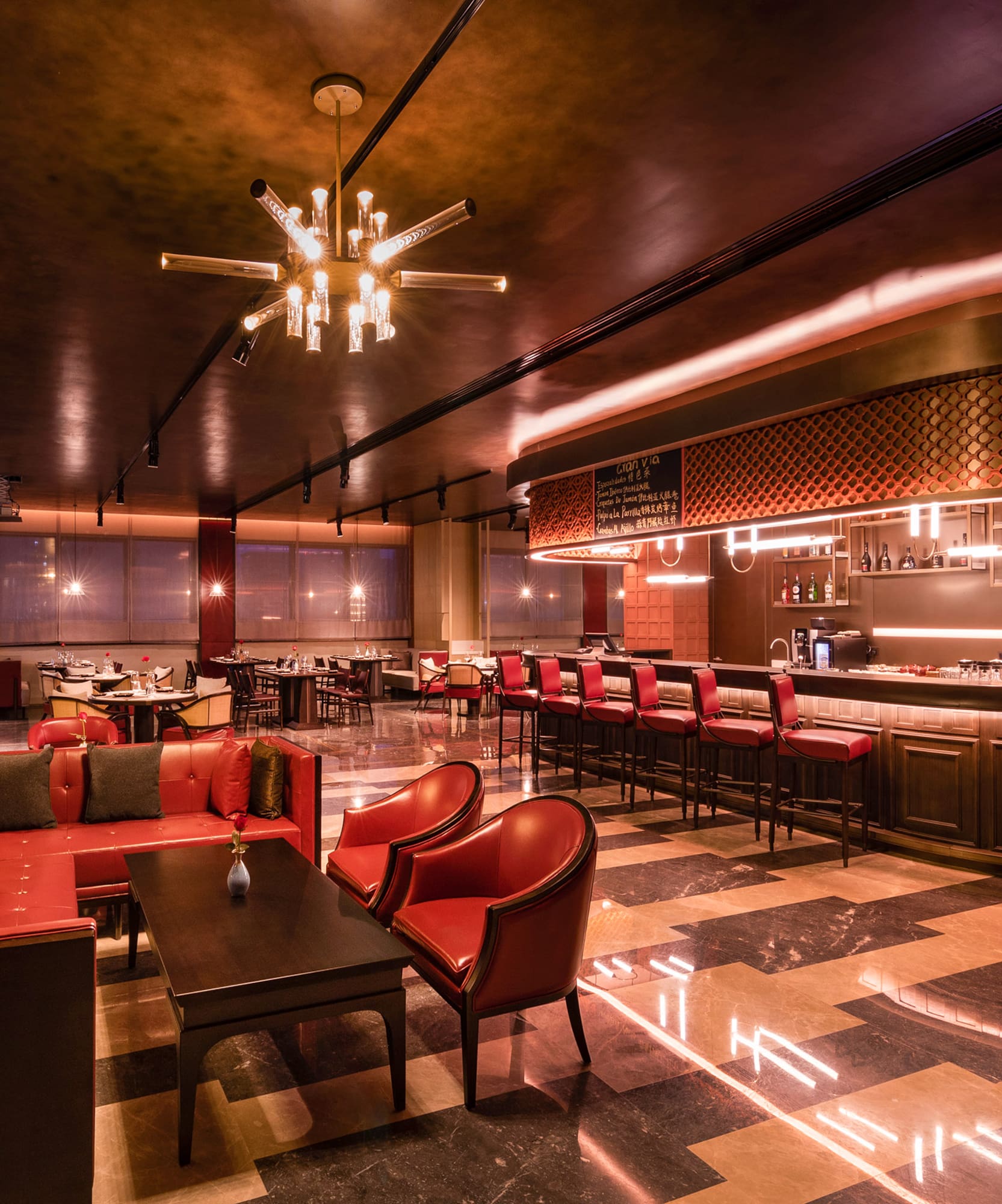 a room with a bar and tables and chairs