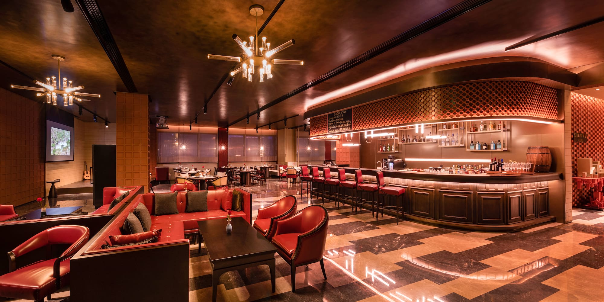 a room with a bar and tables and chairs