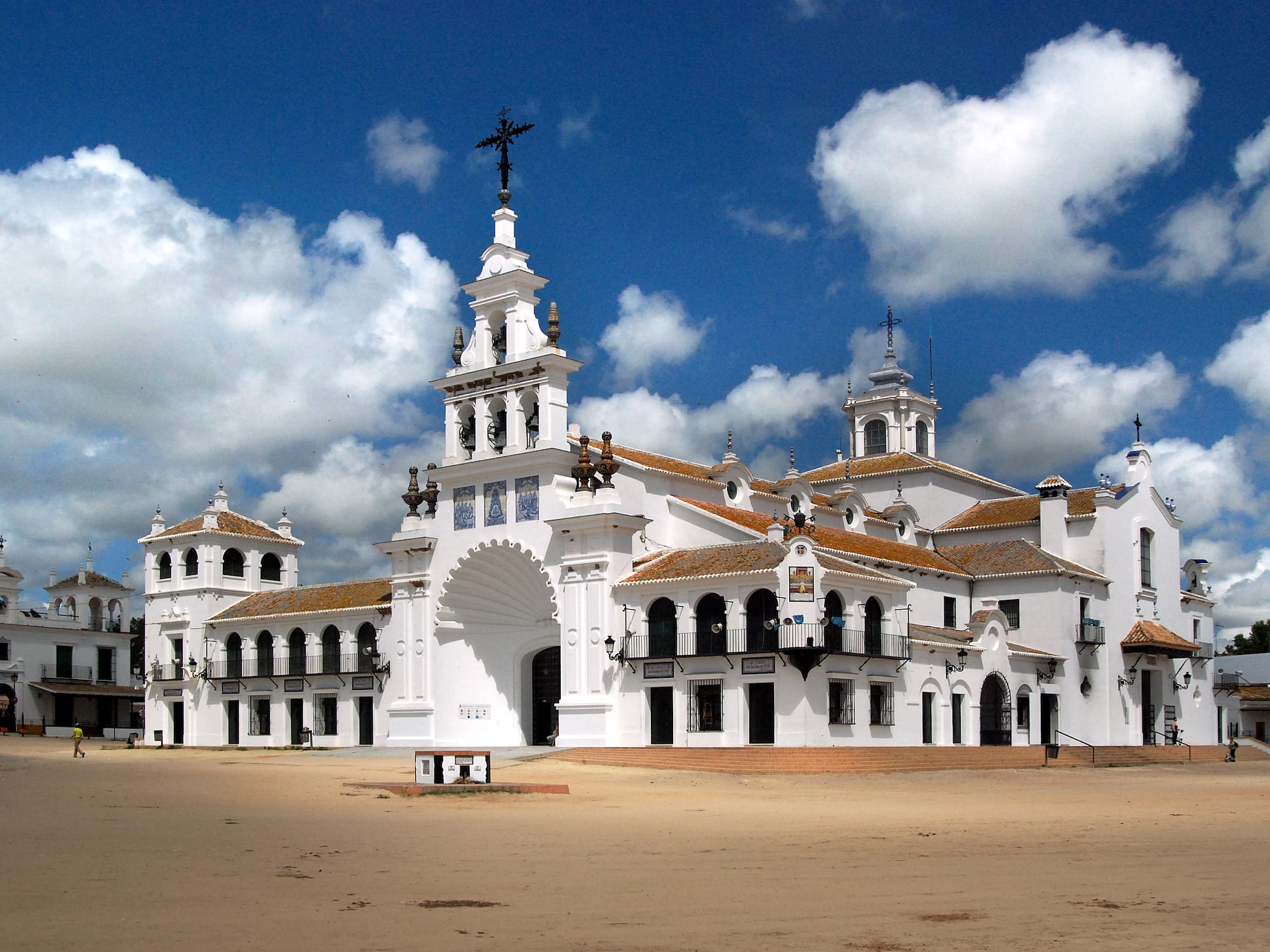 White El Rocío Sanctuary church in Spain, bell tower, cloudy blue sky.