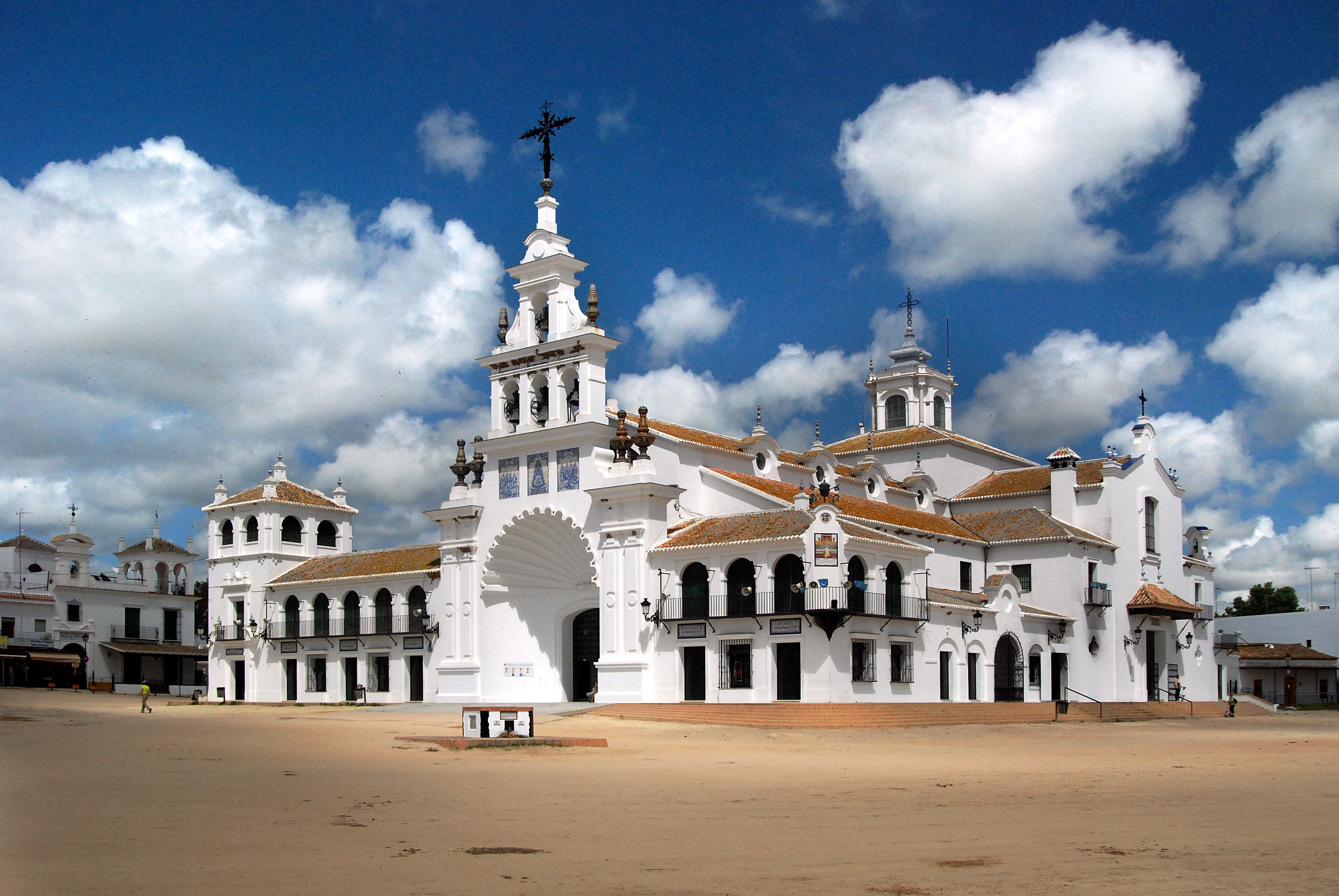 White El Rocío Sanctuary church in Spain, bell tower, cloudy blue sky.