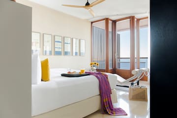 a bed with a tray and a tray of food in a room with a fan and a ceiling fan