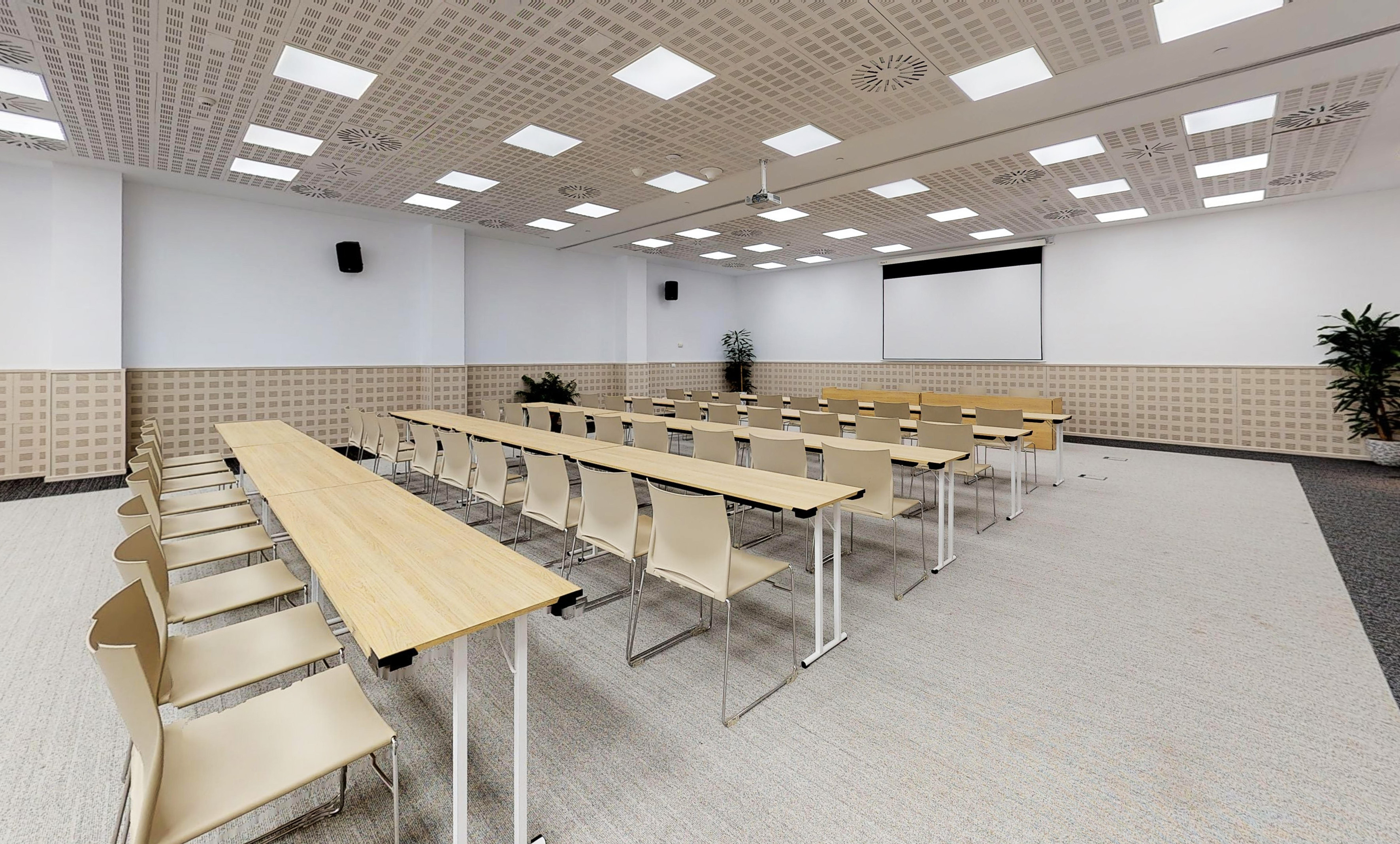 Spacious meeting room with long tables, beige chairs, and presentation screen. - Salón Denia - The Level at Meliá Villaitana, Benidorm