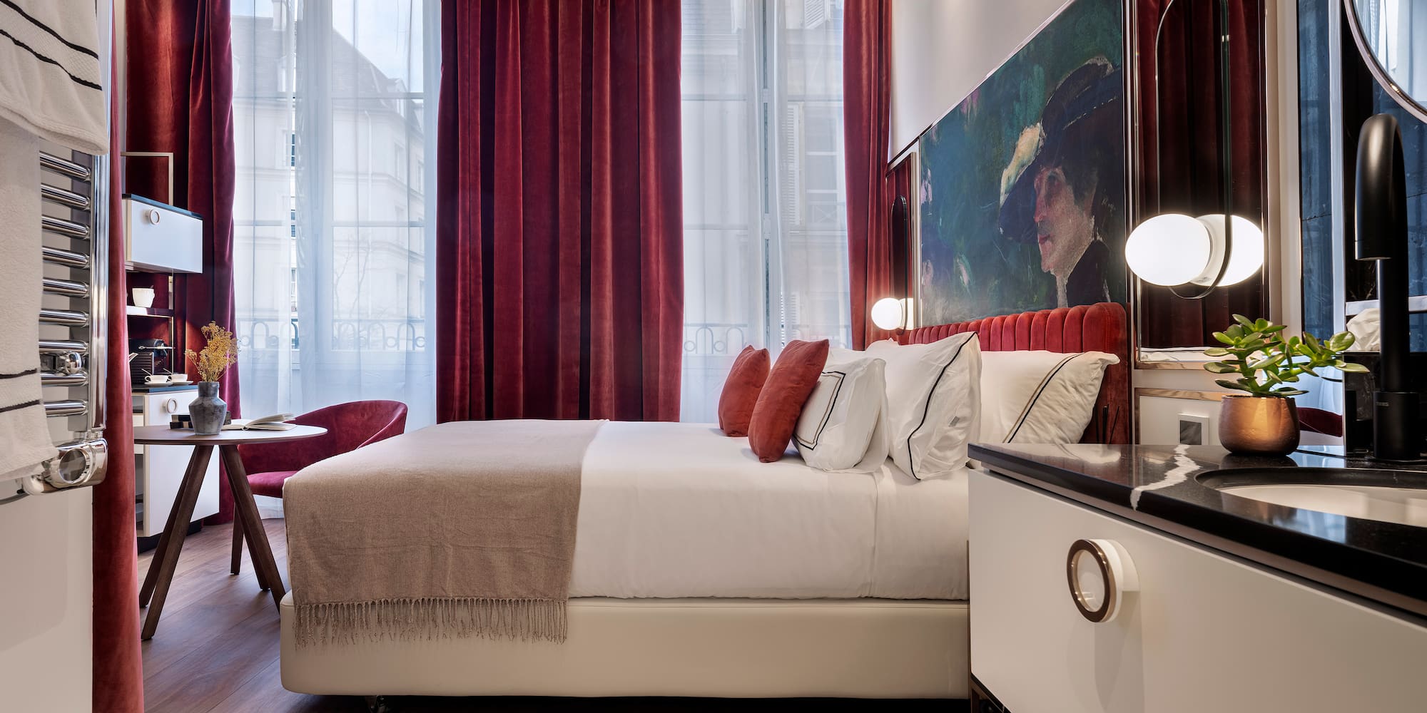 a bedroom with a bed and a table and red curtains