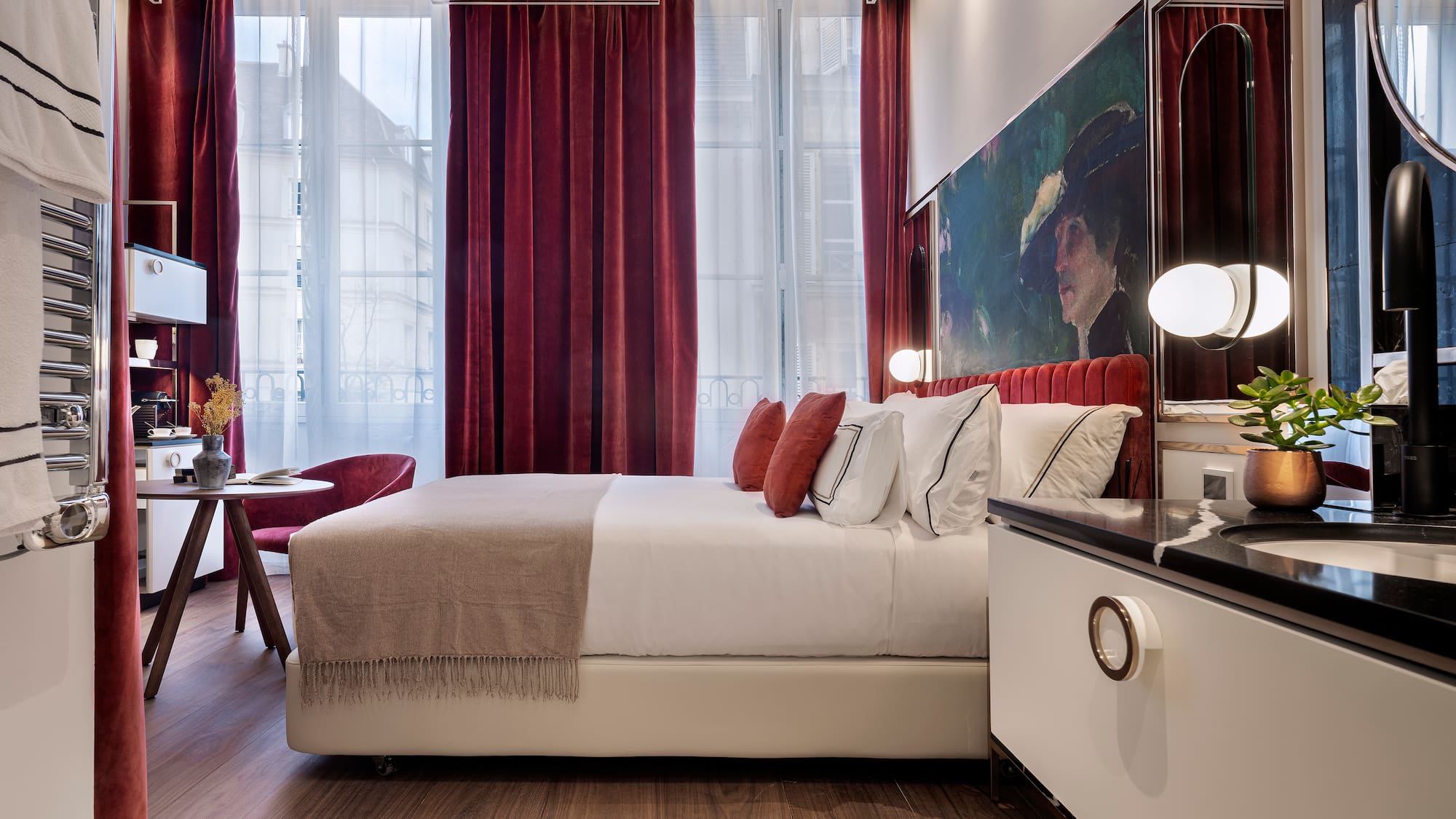 a bedroom with a bed and a table and red curtains