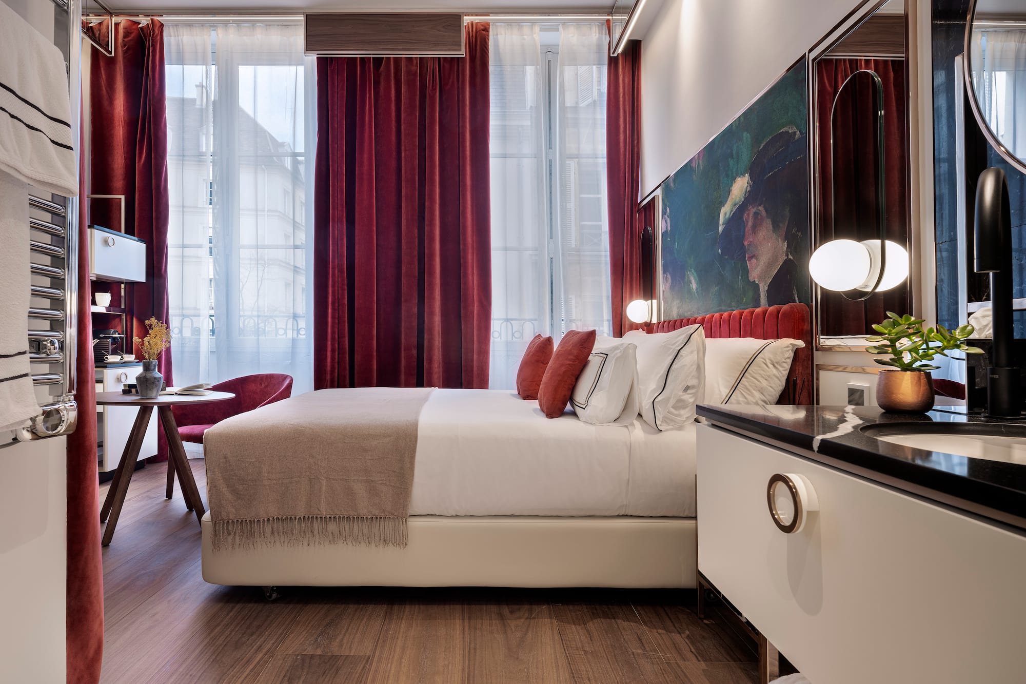 a bedroom with a bed and a table and red curtains