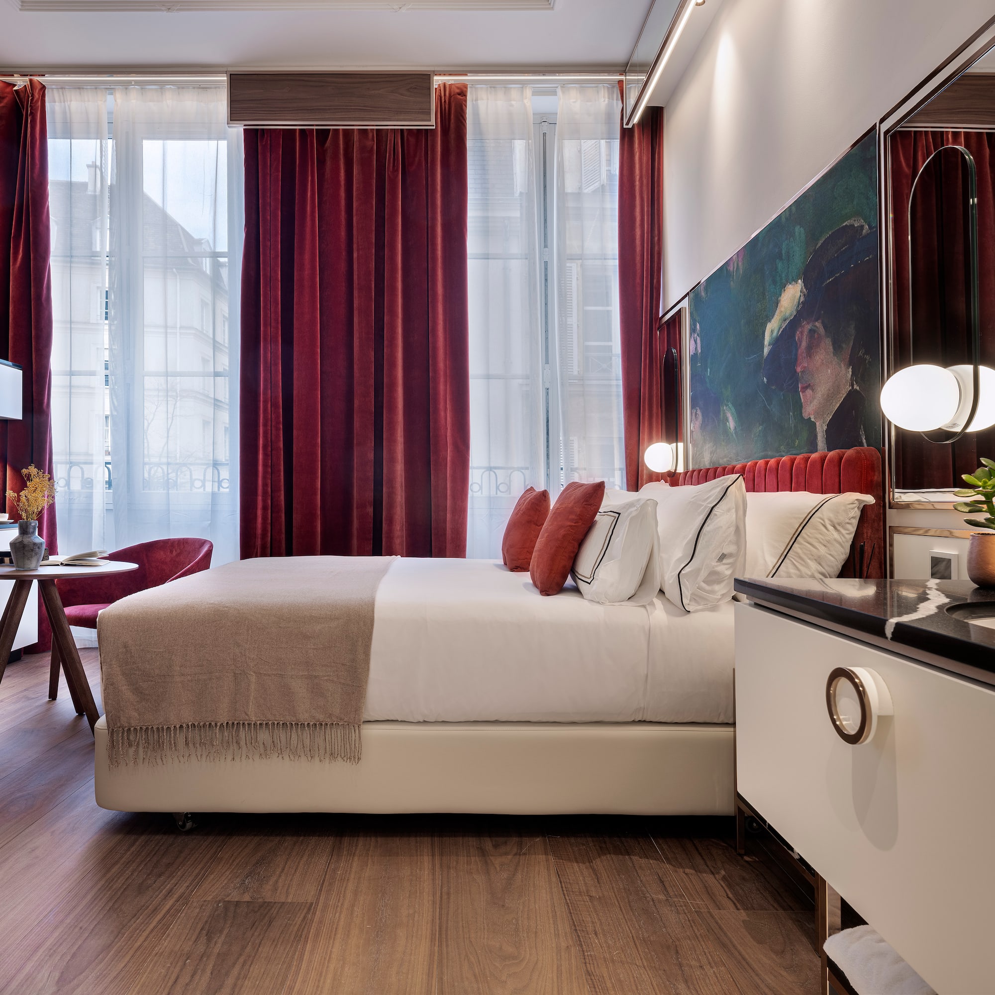 a bedroom with a bed and a table and red curtains