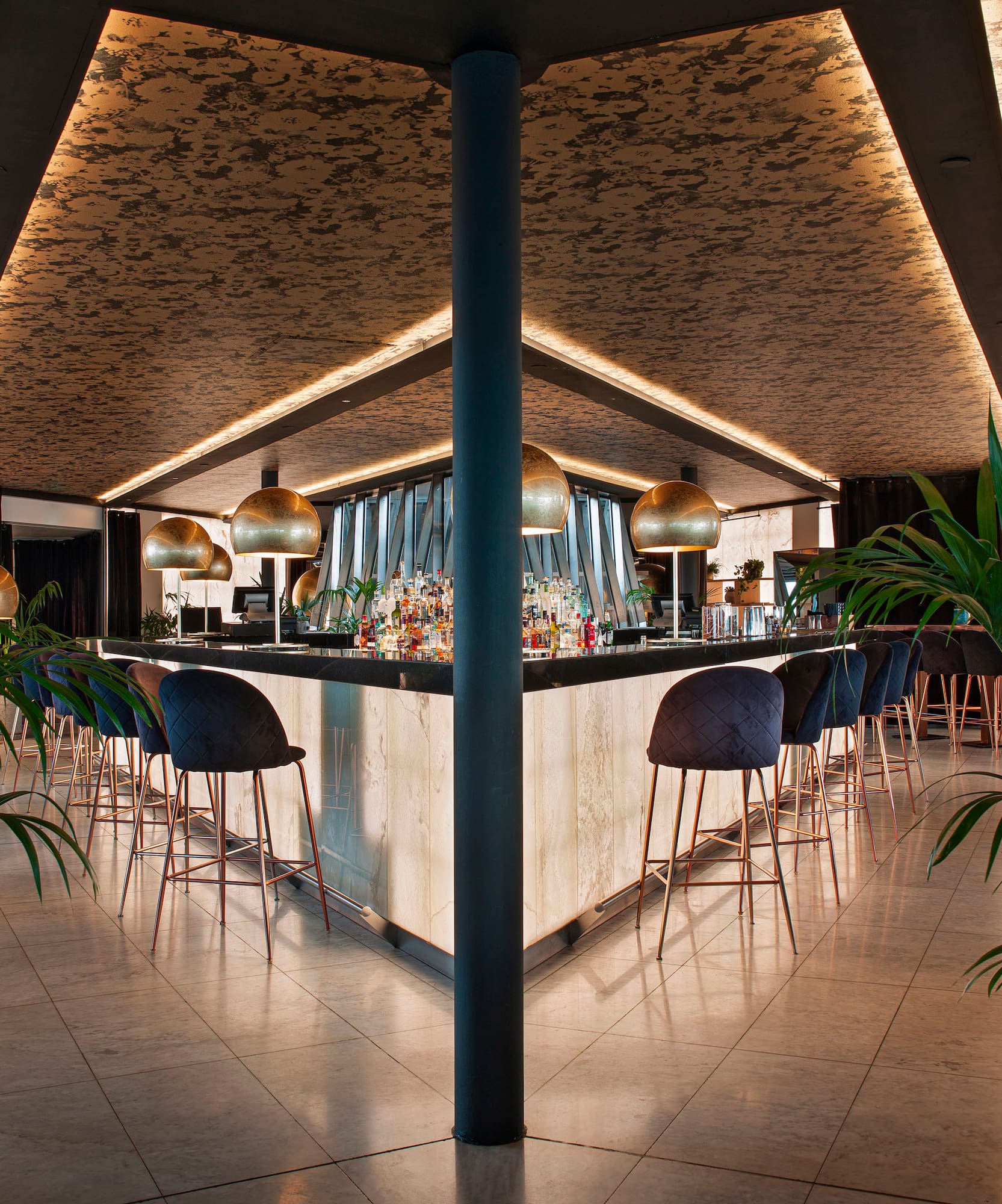 a bar with chairs and plants